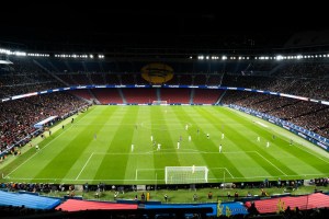 Partido de fútbol en un estadio lleno e iluminado por la noche