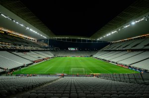 Estadio de fútbol vacío con la cancha iluminada de noche