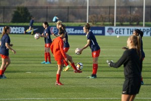 Grupo de mujeres jugando un partido de fútbol en una cancha de césped