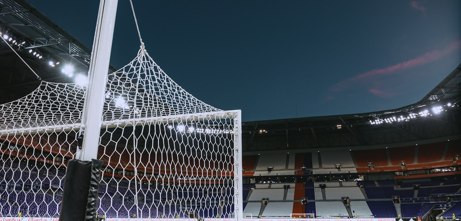 Arco de fútbol blanco con la red vista de cerca sobre el césped