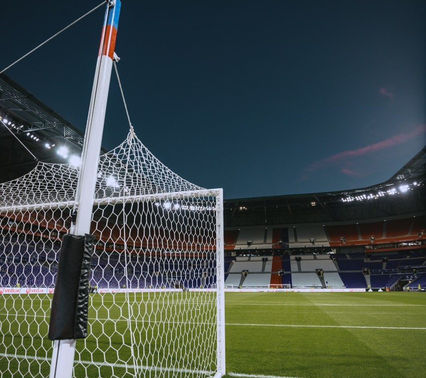 Arco de fútbol blanco con la red vista de cerca sobre el césped