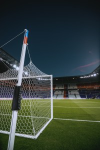 Arco de fútbol blanco con la red vista de cerca sobre el césped