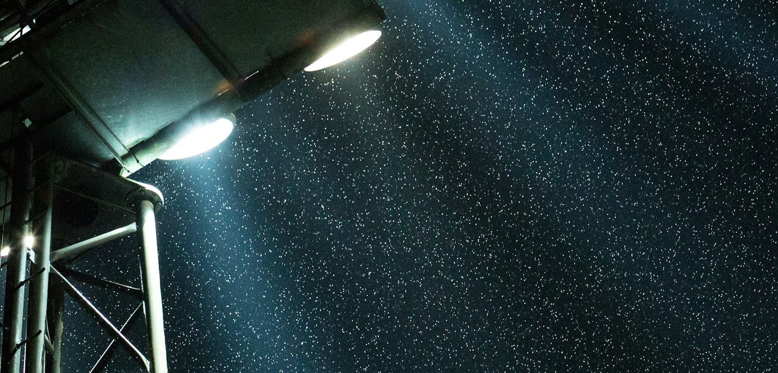 Reflectores de un estadio encendidos en una noche oscura