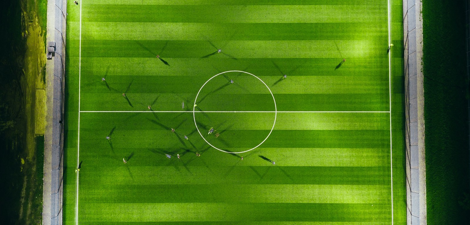 Vista aérea de una cancha de fútbol iluminada por reflectores de noche