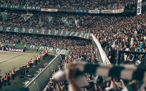 Tribunas llenas de público en un estadio de fútbol iluminado de noche