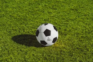 Pelota de fútbol blanca y negra sobre el césped de una cancha