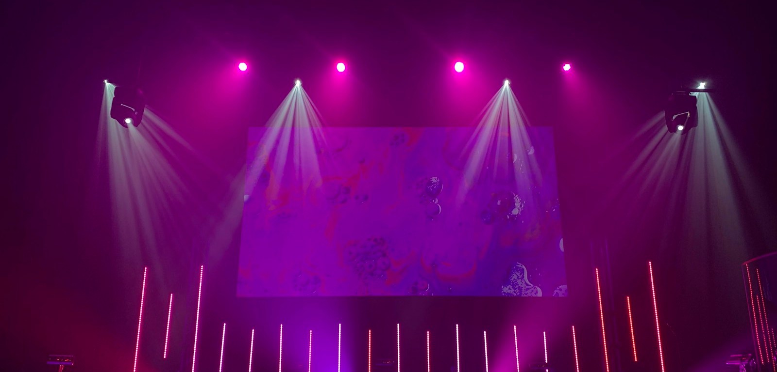 Escenario vacío iluminado con luces moradas y rosas, como el de una gala de premios