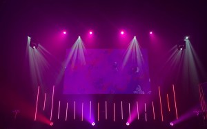 Escenario vacío iluminado con luces moradas y rosas, como el de una gala de premios