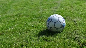 Pelota de fútbol blanca y negra sobre el césped de una cancha